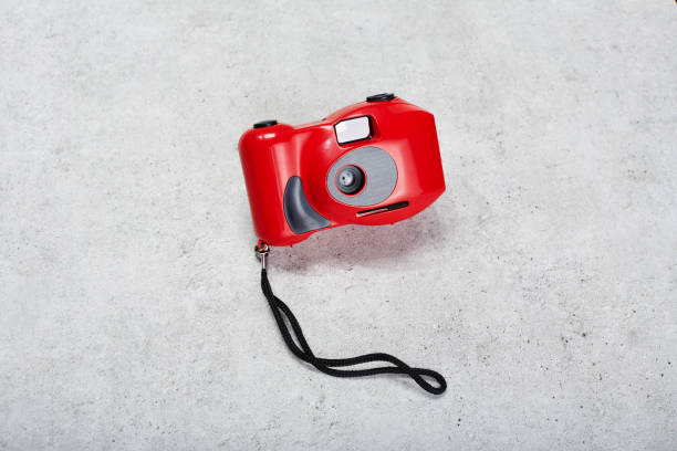 istock Red colored 35mm point and shoot film camera on concrete background 1488832294