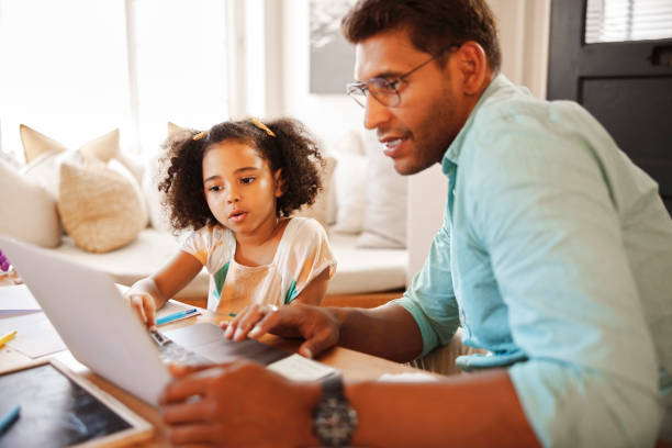 istock Laptop, online education and father with child for e learning support, helping and website support at home. Family, dad and kid or girl with computer for teaching, knowledge and digital development 1488834001
