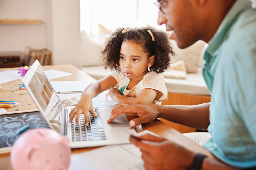 Elearning, help and a father and child with a laptop for money, saving and finance education. Homework, together and a dad with a girl kid reading information on a pc for budget and studying tips