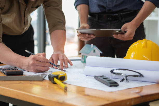 istock Asian engineers brainstorm and measure to document cost estimates and write floor plans for architectural and engineering designs for houses and buildings. 1488834384