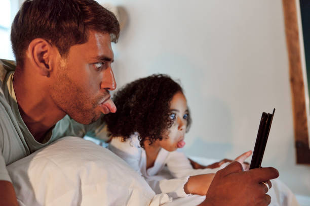 Bedroom, tablet selfie and dad and child pose for crazy memory picture for social media. Internet, bonding and family relax in bed for sleep, relaxation and quality time together dormitorio, tableta selfie y papá y niño posan para una foto de memoria loca para publicar en la aplicación de redes sociales. sitio web en línea, cómico o unión familiar relajarse en la cama para la relajación en el hogar y tiempo de calidad juntos