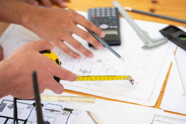 istock Asian engineers brainstorm and measure to document cost estimates and write floor plans for architectural and engineering designs for houses and buildings. 1488836050