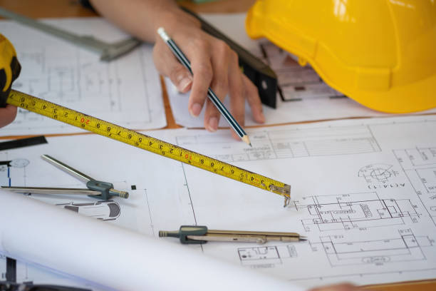istock Asian engineers brainstorm and measure to document cost estimates and write floor plans for architectural and engineering designs for houses and buildings. 1488836559