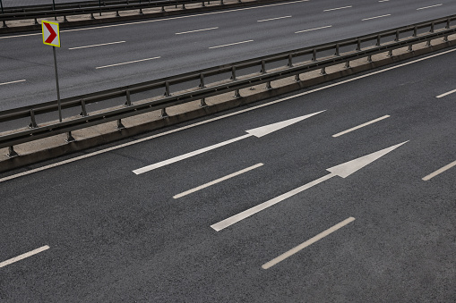 illuminated empty foggy night road with rigid guardrails, traffic barriers or crash barriers