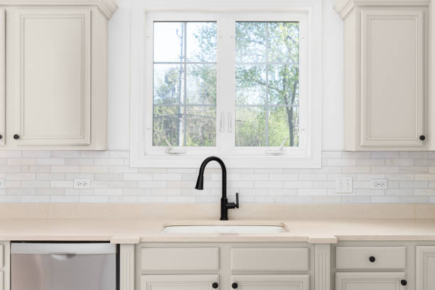 istock A kitchen faucet detail with brown cabinets and subway tile backsplash. 1488843004