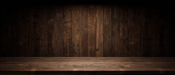 Photo of Old planks wall and table with light empty space. Vintage wooden background and spotlight showroom.
