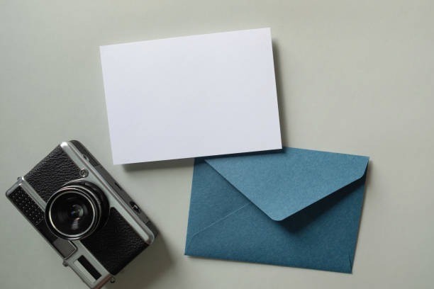 istock White blank greeting or invitation card and envelope with vintage camera on green background. Mock up presentation. 1488845365