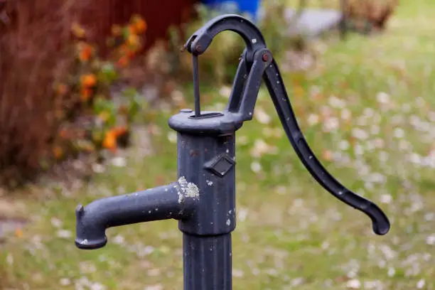 hand-operated water pump with long handle, water from a deep well at Roback