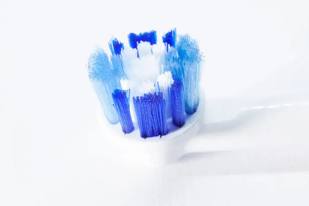 electric toothbrush head with blue and white straws in close-up