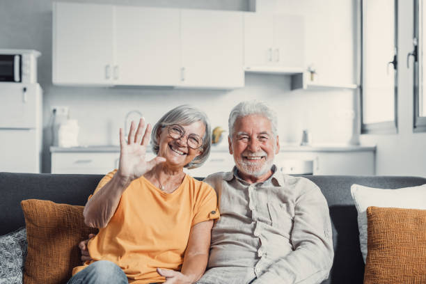 istock Sixty years couple, elderly parents communicates with grown up children using modern technologies makes video call, wave hands gesture of hello or goodbye sign, older generation and internet concept 1488847072