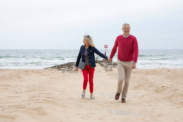 istock Cheerful mature couple walking on a beach 1488847470