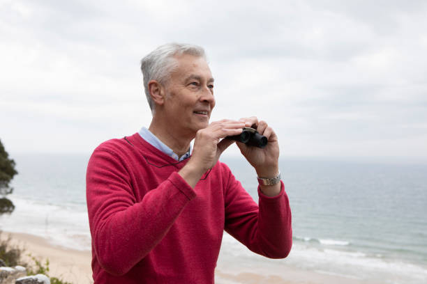 istock Mature man and binoculars at the seaside 1488849233
