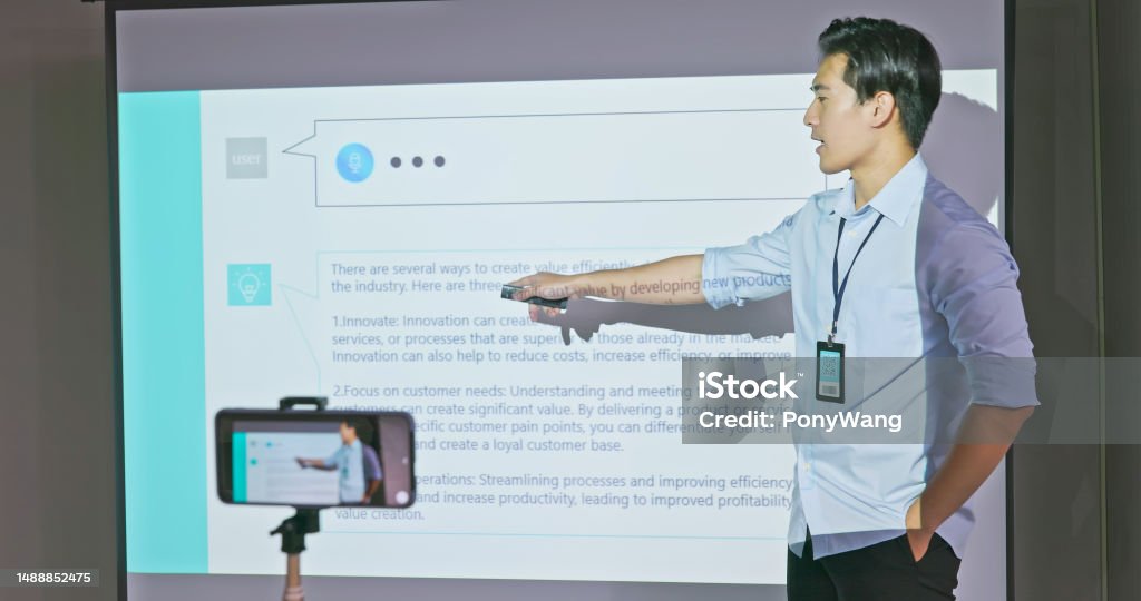 teacher in adult education class learning online concept - asian male teacher is teaching computer programming design in adult education class with slides on screen and has live streaming through mobile Live Streaming Stock Photo