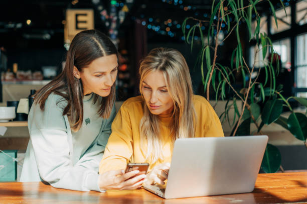 istock Two business women work behind the counter using electronic gadgets. 1488853392