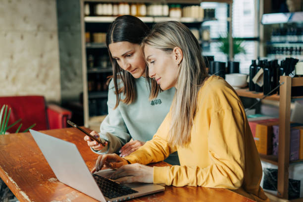 istock Two business women work behind the counter using electronic gadgets. 1488853393