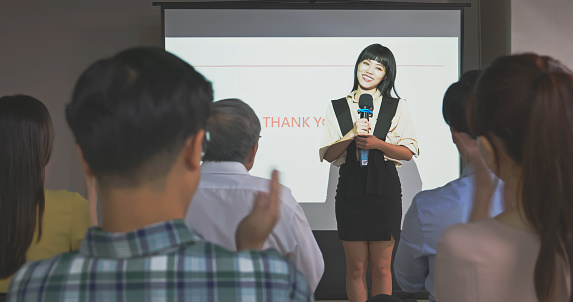 asian woman bow after finishing presentation and audience applause