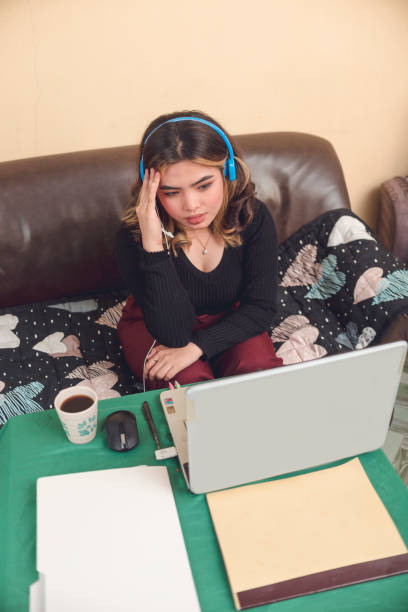 istock A female vlogger in her living room is having a hard time deciding which topic she will use in her upcoming live feed. 1488861227