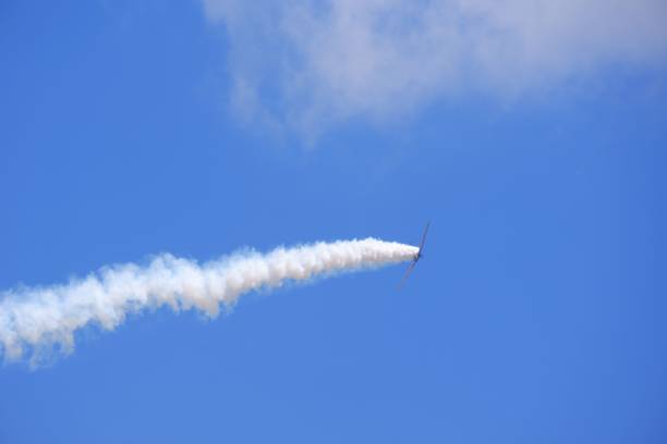 plane climbing up at cloudy sky with smoke at the back - vfr imagens e fotografias de stock