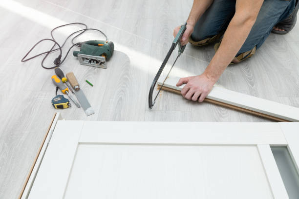istock Worker assembles a door frame by cutting off the part with a hand saw. 1488865618