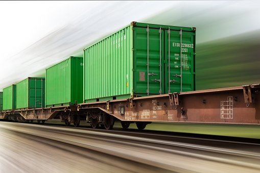 high speed cargo train loaded with ship containers. Heavy motion blur.