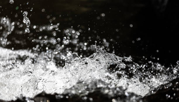 Close focus on fast moving water in river with stopped motion technique.
