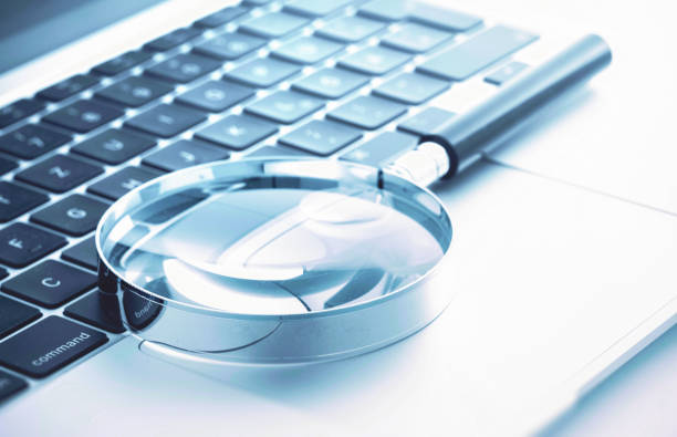 istock Magnifying glass on laptop keyboard 1488880002