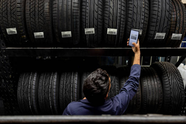 Employee scanning a bar code on a tire at a garage shop