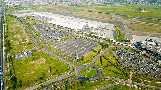 An aerial view of a bustling airport with lush green grass visible in the foreground