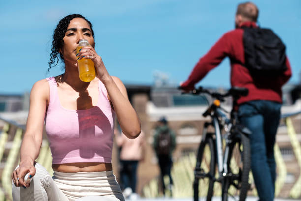 istock Sport woman sitting on floor drinking from a bottle. 1488884753
