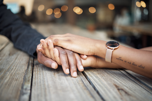 Holding hands, couple zoom and restaurant date of black people together with trust and support. Hope, empathy and love of woman and man with compassion, gratitude and sympathy in a cafe with bokeh