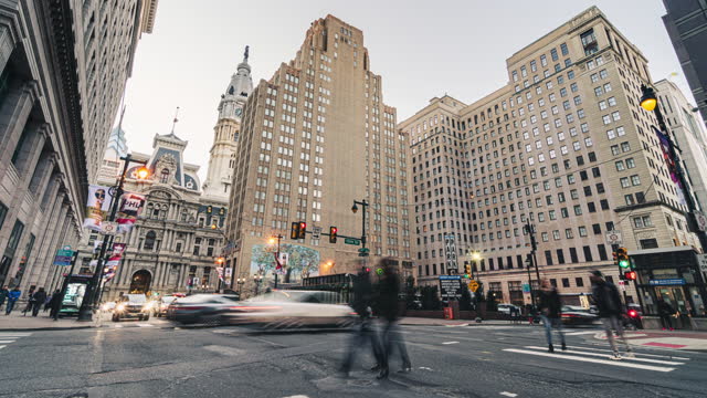 Time lapse of Philadelphia's landmark historic City Hall with traffic car and crowd pedestrian crossroad in Pennsylvania city street, United States