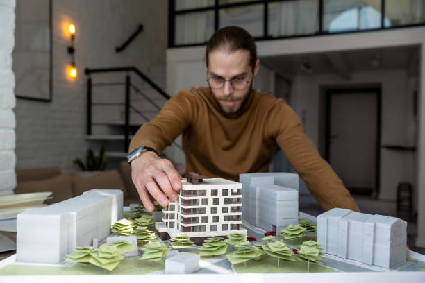 istock Man architect working in office on creation of new residential complex designing layout of buildings 1488891406