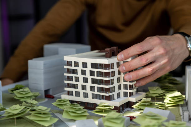 istock Man architect working in office on creation of new residential complex designing layout of buildings 1488891422