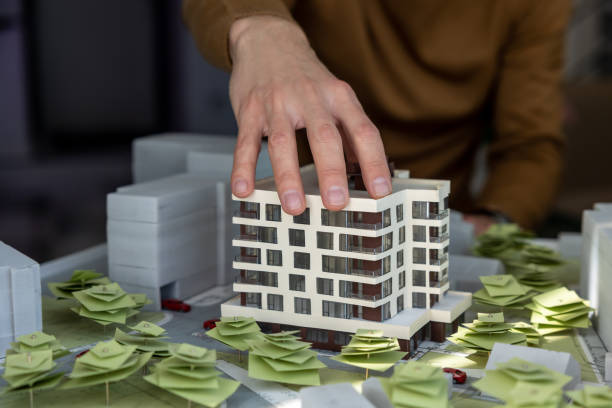 istock Man architect working in office on creation of new residential complex designing layout of buildings 1488891429