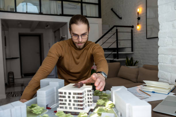 istock Man architect working in office on creation of new residential complex designing layout of buildings 1488891439