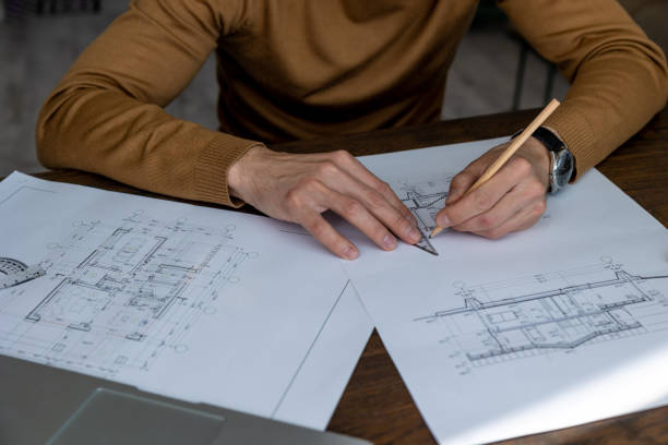 istock Architect drawing blueprint sketching design of house, making architectural construction building. 1488891469