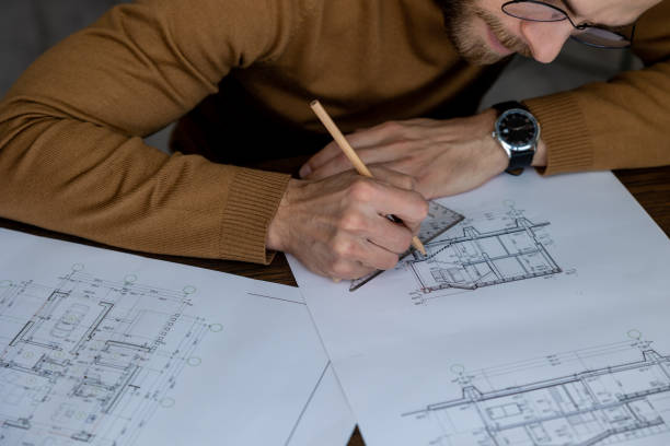 istock Architect drawing blueprint sketching design of house, making architectural construction building. 1488891471