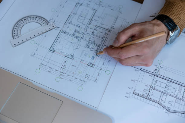 istock Architect drawing blueprint sketching design of house, making architectural construction building. 1488891494