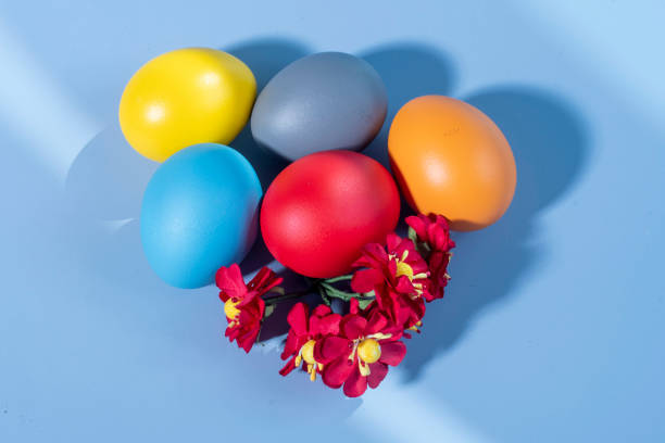 istock Colorful eggs, symbolizing Easter, on a colorful background and flowers 1488893474