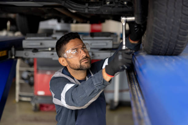 istock Mechanic working at an auto repair shop fixing a broken car 1488894424