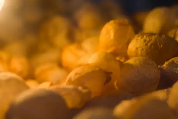 Fuchka or panipuri kept inside glass box for selling. It is made of flour and semolina and deep fried till crunchy hollow round shape.