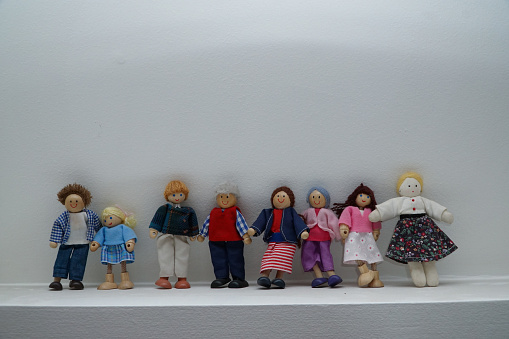 Lots of different people represent by wooden dolls