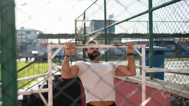 istock Adult athlete man doing pull-ups in the park 1488900319
