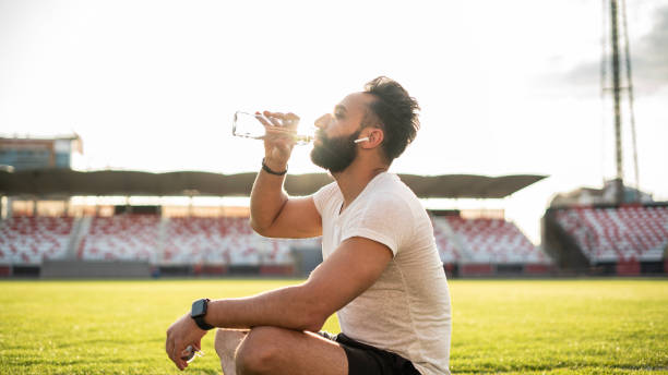istock Adult man taking a water break while jogging 1488900435