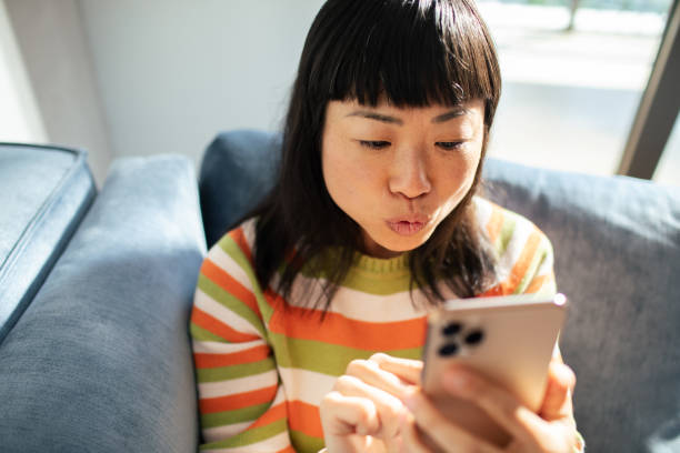 istock Young Japanese Woman using a smart phone at home 1488901847