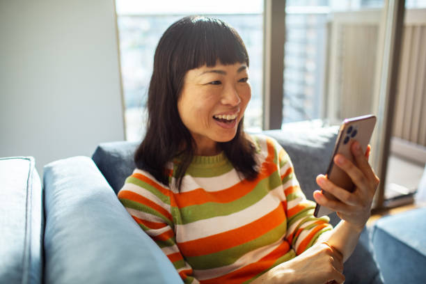 istock Young Japanese Woman using a smart phone at home 1488903343