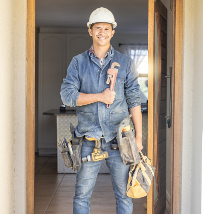Handyman smile in portrait, maintenance and tools with construction and home renovation with builder. Professional, contractor and DIY skills, architecture and wrench, male with helmet for safety