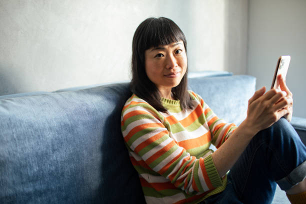 istock Young Japanese Woman using a smart phone at home 1488903649