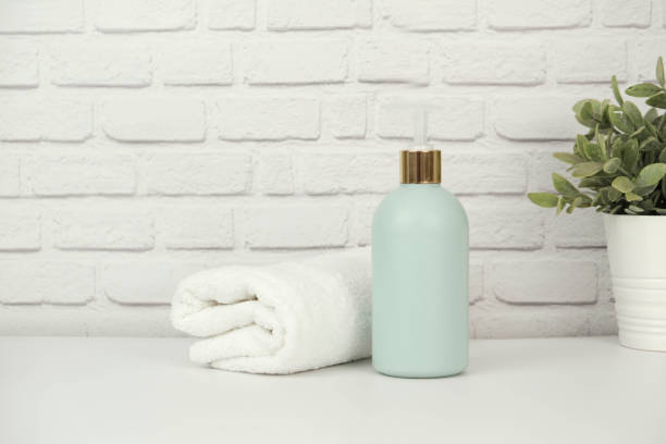 istock A green plastic bottle of cleaning agent with space for text and white moss twisted towel with green flower on a white bricks background. 1488905049