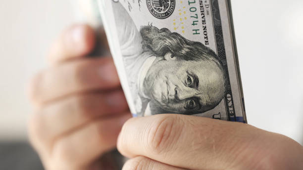 istock Man counting american dollars banknotes 1488905585